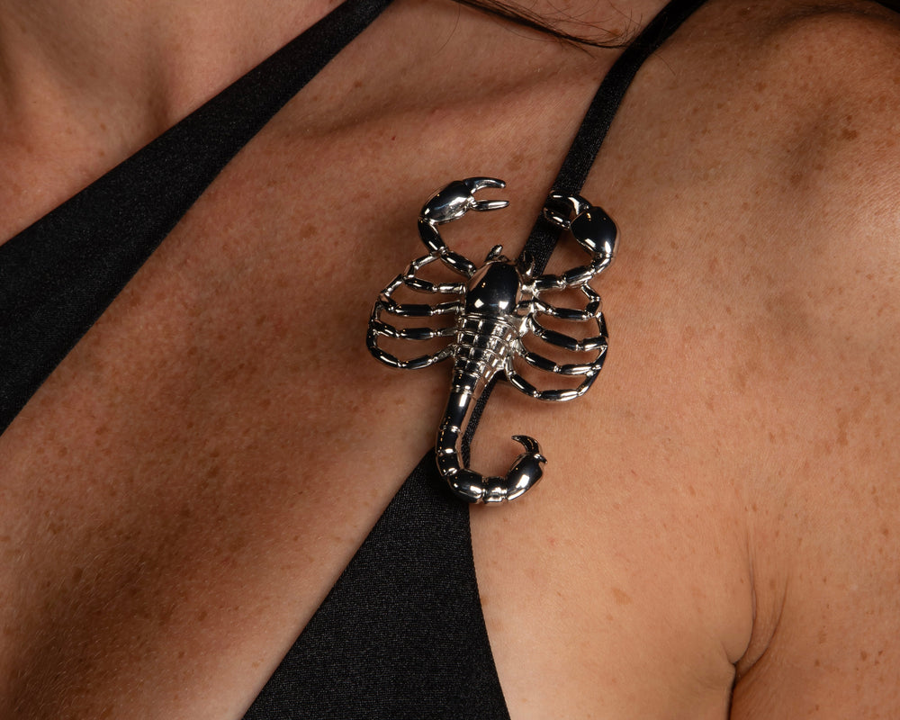 Black asymmetric one piece swimsuit with metal Scorpion hardware, by Ciao Bella Monte Carlo. Scorpion swimsuit.